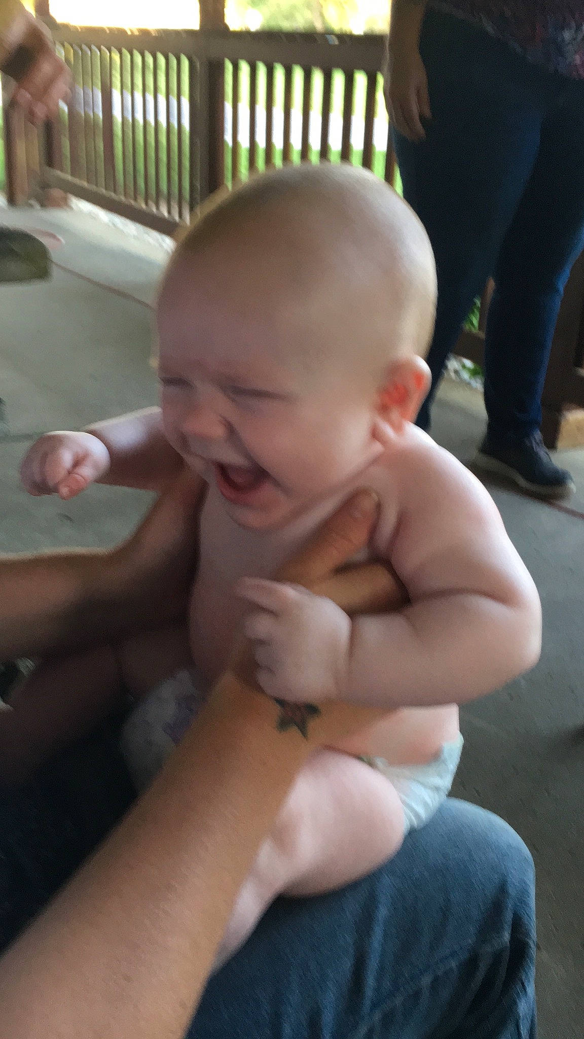 Logen is registered to the contest to win money with this photo: arm, baby, cheek, child, face, finger, hand, leg, mouth, person, sitting, skin, smile, thumb, toddler, vacation