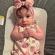 Maddie joined the competition — help win amazing prizes! baby, headband, pink_bow, infant, strawberry_print, clothing, hands, face, blue_eyes, cute, portrait, lying_down, fabric, texture, child, soft_lighting, expression, close_up, person, young_child