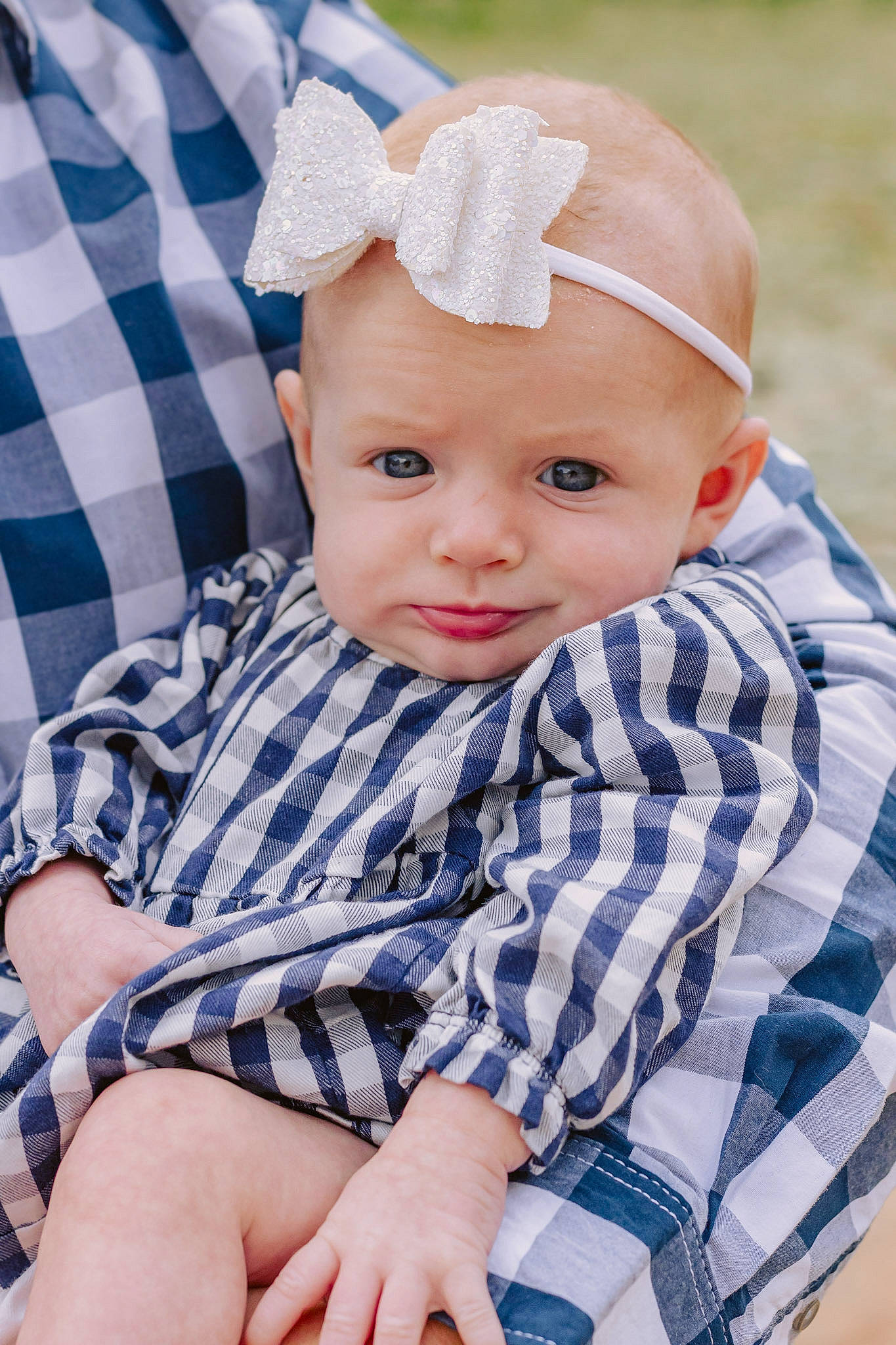 Dalila is registered to the contest to win money with this photo: azure, baby, baby_toddler_clothing, cap, cheek, child, collar, electric_blue, grass, hat, headwear, iris, pattern, person, plaid, portrait_photography, sitting, skin, sleeve, tartan