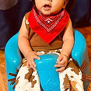 Messiah joined the competition — help win amazing prizes! baby, child, cowboy_hat, red_bandana, blue_seat, brown_shirt, patterned_boots, wooden_floor, curious_expression, indoor, portrait, cute, costume, cowboy_pants, sitting, hands, face, person, footwear, young_child