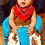 baby, child, cowboy_hat, red_bandana, blue_seat, brown_shirt, patterned_boots, wooden_floor, curious_expression, indoor, portrait, cute, costume, cowboy_pants, sitting, hands, face, person, footwear, young_child