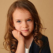 Maëline participe au concours pour gagner de l'argent avec cette photo : child, girl, portrait, face, curly_hair, blue_eyes, hand, expression, closeup, young, person, studio, warm_background, casual_clothing, innocence, soft_lighting, natural, beauty, cute, thinking