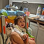 Taro participe au concours pour gagner de l'argent avec cette photo : baby, kitten, high_chair, kitchen, smiling, child, pet, cat, indoor, furniture, colorful, seat, cute, young, playful, domestic, happy, person, animal, cozy