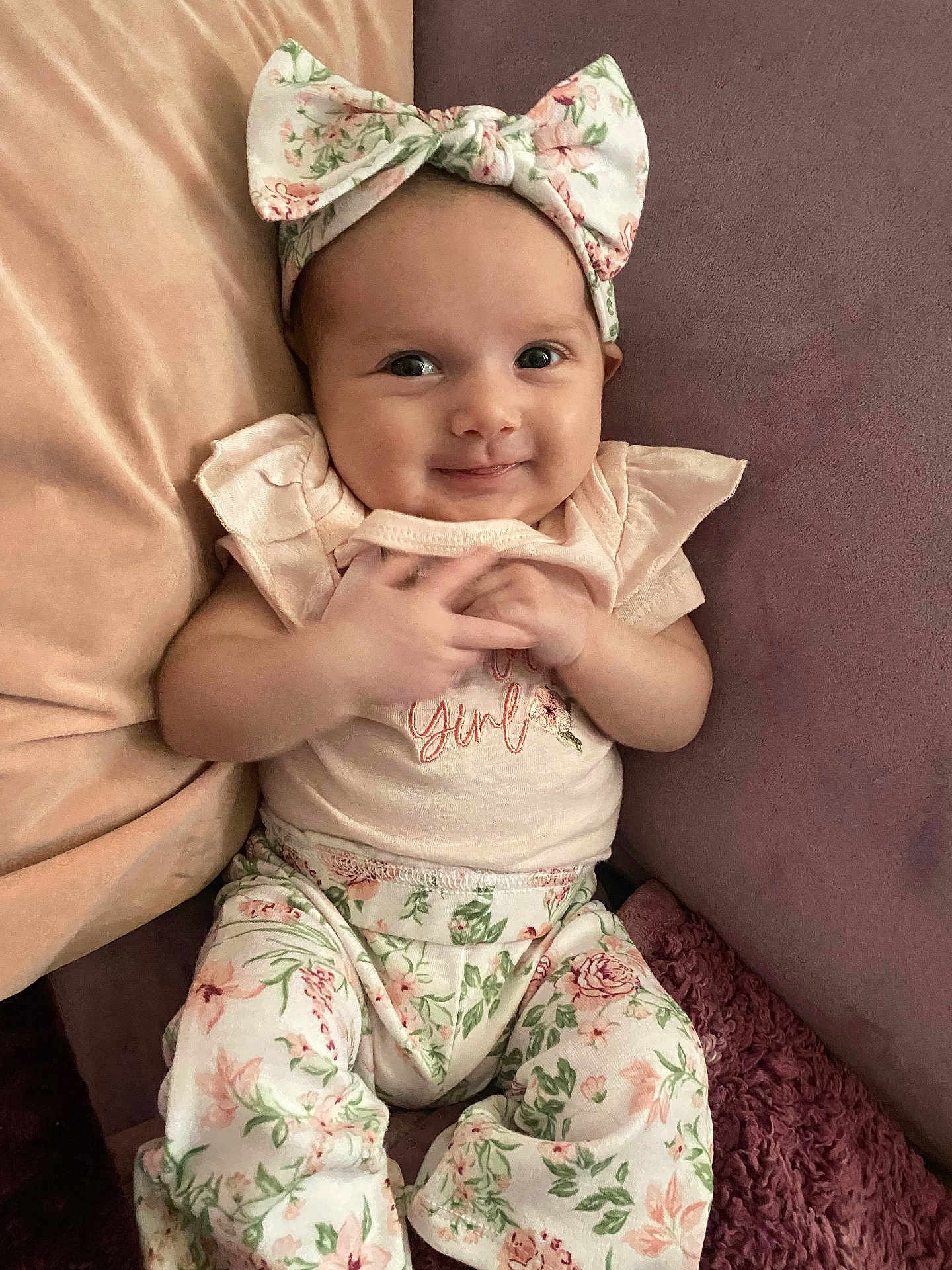 Amira Rose joined the competition — help win amazing prizes! baby, infant, girl, smiling, headband, bow, floral, pants, couch, pillow, pink, pastel, cute, child, clothing, portrait, happy, indoors, soft, comfort