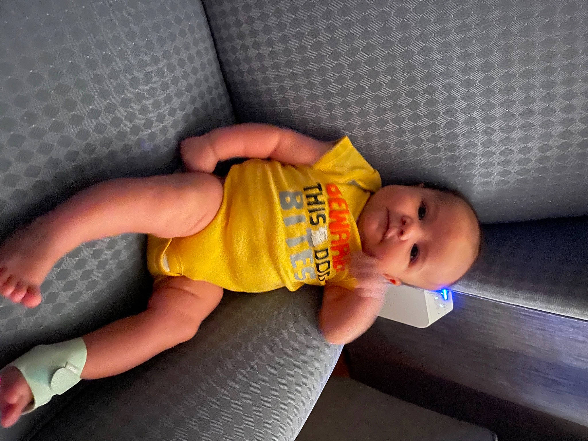 Craig is registered to the contest to win money with this photo: abdomen, baby, baby_toddler_clothing, child, comfort, elbow, finger, floor, flooring, foot, human_leg, knee, mouth, person, smile, sock, thigh, thumb, toddler, trunk