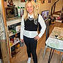 Chelsea a rejoint le concours — aidez-le/la à gagner de superbes lots ! child, girl, smiling, standing, indoor, kitchen, clothing, white_shirt, black_vest, pants, sneakers, plants, table, chair, television, mugs, wood_floor, home, casual, blonde_hair
