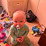 Liam is registered to the contest to win money with this photo: baby, child, pacifier, pajamas, dinosaur, toy, stuffed_animal, carpet, floor, room, indoor, child_playing, cute, face, smile, colorful, clothing, person, home, playtime