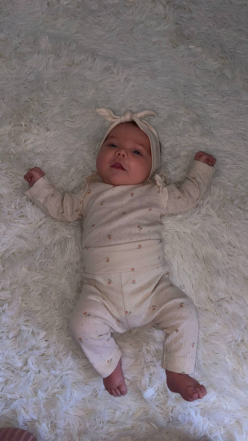 Inaya a rejoint le concours — aidez-le/la à gagner de superbes lots ! baby, baby_toddler_clothing, cheek, child, comfort, face, flooring, fun, fur, happy, head, headwear, linens, nose, pattern, person, sitting, skin, sleeve, smile