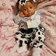 Vivian is registered to the contest to win money with this photo: baby, infant, child, blanket, pink, pattern, clothing, headband, bow, face, socks, cute, portrait, soft, fabric, lying_down, expression, black_and_white, animal_print, cozy