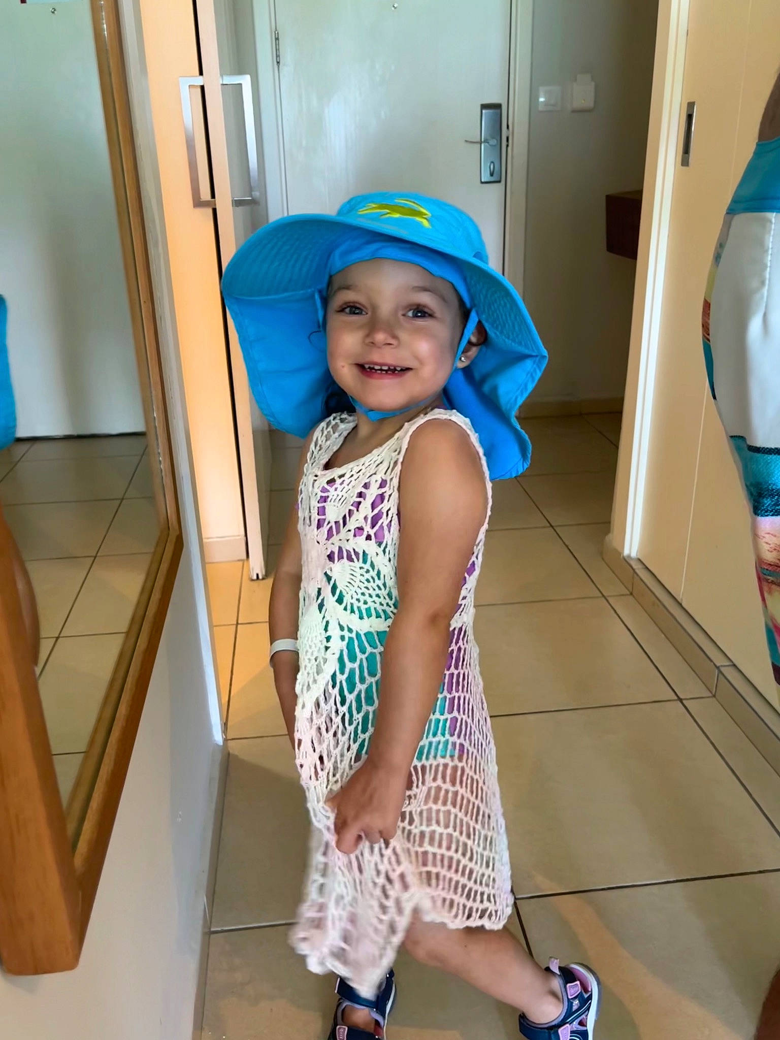 Anastasia is registered to the contest to win money with this photo: baby_toddler_clothing, blue, child, door, electric_blue, floor, flooring, fun, happy, hat, headwear, human_leg, joy, knee, leg, person, product, sleeve, smile, standing