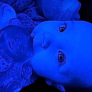 Melanie joined the competition — help win amazing prizes! baby, pacifier, closeup, blue_light, infant, face, eyes, clothing, lying_down, portrait, child, cute, patterned_clothing, reflection, monochrome, soft_texture, indoors, young_child, head, expression