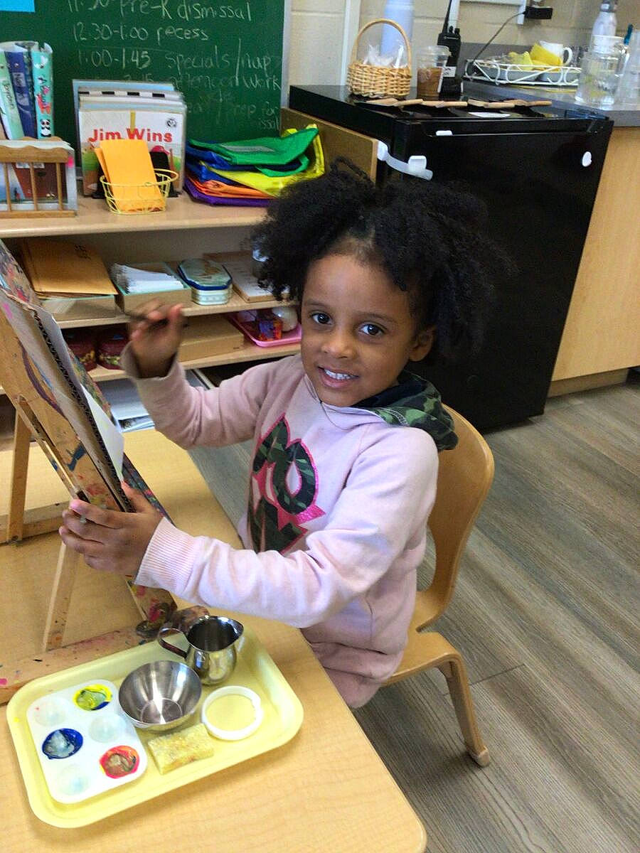 Alannah is registered to the contest to win money with this photo: bookcase, chair, child, countertop, desk, flooring, fun, furniture, gadget, game_controller, input_device, joy, person, play, room, shelf, shelving, sitting, smile, snapshot