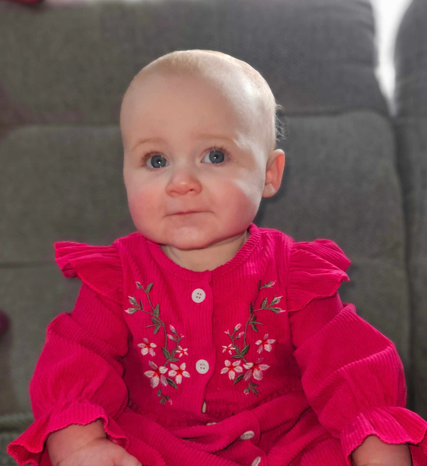 Angelina Rose joined the competition — help win amazing prizes! baby, child, blue_eyes, pink_clothing, floral_embroidery, couch, indoor, portrait, cute, infant, soft_lighting, sitting, long_sleeve, face, young_child, comfortable, expression, person, clothing, home