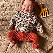 Adèle a rejoint le concours — aidez-le/la à gagner de superbes lots ! baby, infant, smiling, leopard_print, headband, bow, rust_color, pants, toy_deer, quilted_blanket, beige, wooden_floor, happy, lying_down, cute, child, indoor, cozy, playful, portrait
