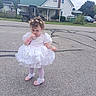 child, toddler, girl, portrait, outdoor, street, dress, white_dress, pink_shoes, curly_hair, hair_bows, necklace, bracelet, standing, residential_area, house, road, parked_car, utility_vehicle, trees