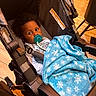 Akyrie joined the competition — help win amazing prizes! baby, pacifier, stroller, blanket, blue_blanket, snowflake_pattern, indoor, child, infant, seat_belt, wooden_floor, curly_hair, clothing, face, person, cozy, wrapped, looking, cute, young_child