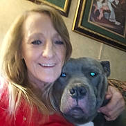 Rowdy joined the competition — help win amazing prizes! animal, blurry, casual, companion, couch, dog, face, furniture, head, home, hug, human, indoor, painting, pet, portrait, red_clothing, smile, wall, woman