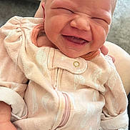 Paisley is registered to the contest to win money with this photo: baby, newborn, smiling, onesie, clothing, hand, pink, face, infant, cute, joyful, expression, person, child, portrait, fingernails, soft, closeup, feather_pattern, cozy