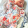 newborn, baby, sleeping, onesie, floral_pattern, blanket, soft, infant, peaceful, hand, face, cute, cozy, child, portrait, resting, indoors, clothing, toddler, bed