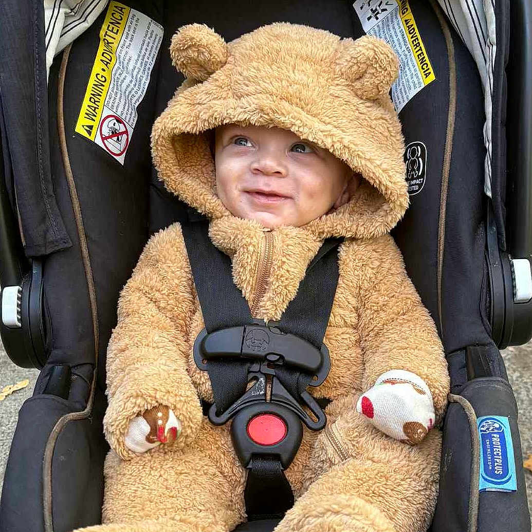 Sora joined the competition — help win amazing prizes! baby, car_seat, child, cute, cute_outfit, fuzzy_clothing, hood, infant, mammal_costume, outdoor, person, plush, seatbelt, smile, toddler, transportation, warm_clothing, wearing, young_child, zipper