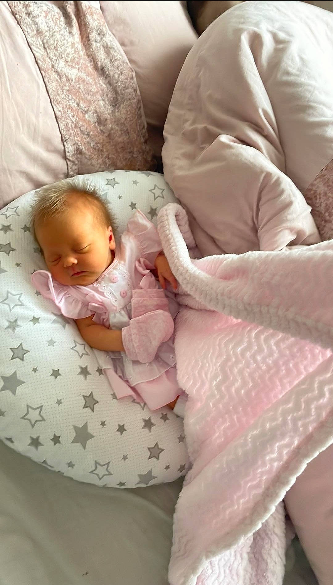 Blakely is registered to the contest to win money with this photo: abdomen, baby, baby_products, baby_safety, baby_sleeping, baby_toddler_clothing, bedding, bedtime, cheek, child, comfort, couch, face, linens, person, pink, room, sitting, sleeve, textile