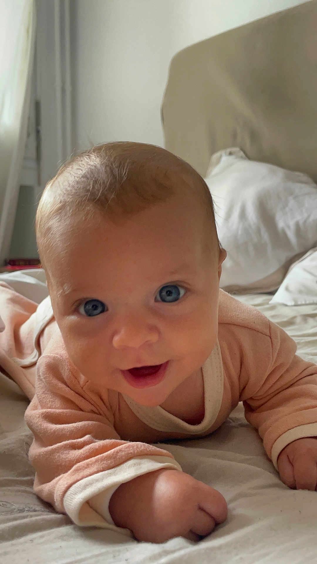 Ambre participe au concours pour gagner de l'argent avec cette photo : baby, infant, child, blue_eyes, smiling, cute, bed, pillow, sleepwear, lying_down, indoors, cozy, soft_light, portrait, person, closeup, happy, skin, head, hand