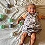 Ambre a rejoint le concours — aidez-le/la à gagner de superbes lots ! baby, infant, child, smiling, floral_dress, orange_shirt, plastic_balls, beige_blanket, lying_down, playful, happy, cute, indoors, soft_lighting, skin, hand, legs, toy, colorful, childrens_toys