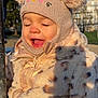 toddler, child, hat, knitted_hat, ears, coat, furry_coat, leopard_print, outdoor, sunlight, happy, smiling, face, closed_eyes, winter_clothing, park, nature, hand, person, blue_sky