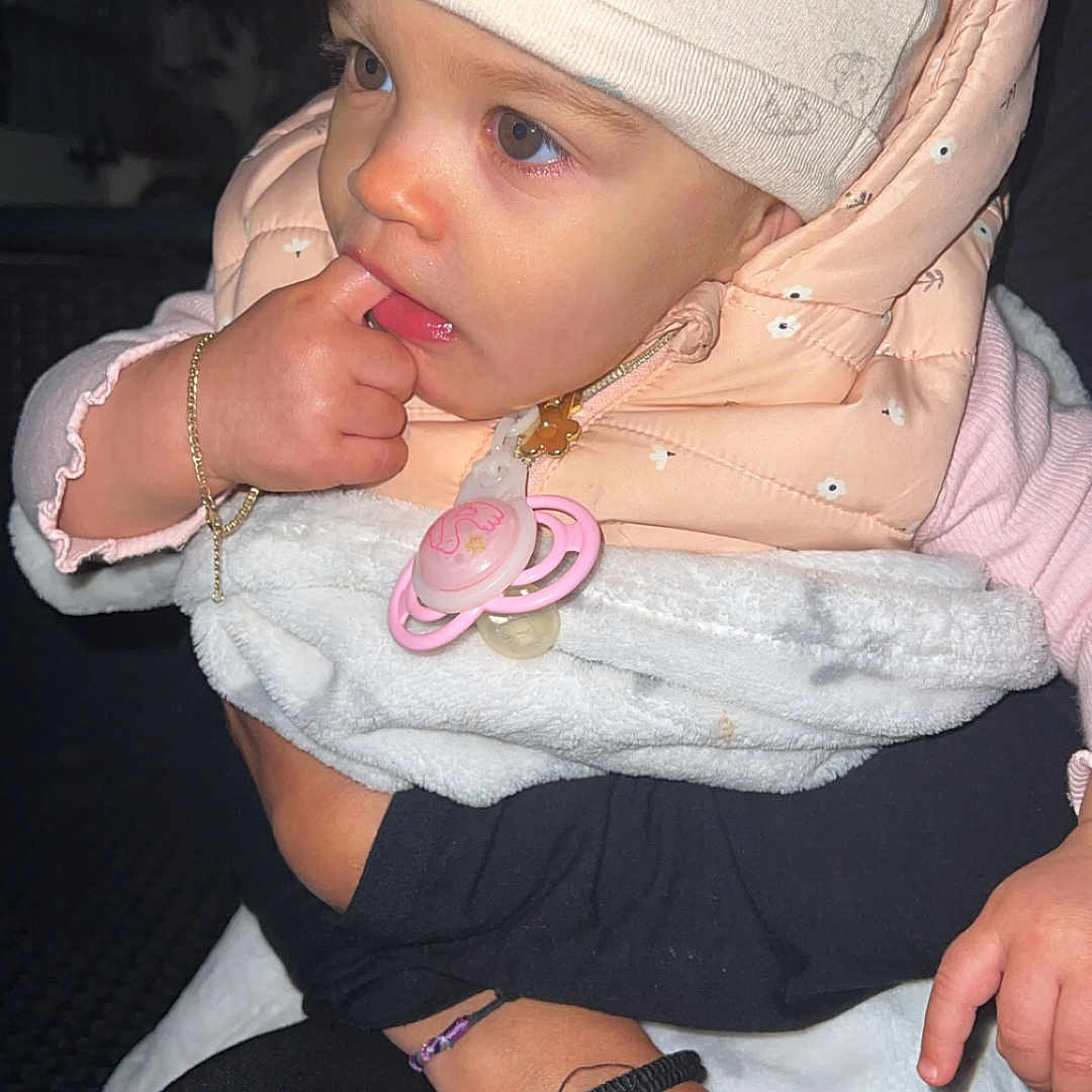 Mia a rejoint le concours — aidez-le/la à gagner de superbes lots ! adult_hand, baby, blanket, bracelet, child, clothing, cozy, cute, face, finger, hand, hat, indoor, infant, jacket, pacifier, person, portrait, ring, warm