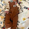 Jermoni joined the competition — help win amazing prizes! baby, blanket, pacifier, clothing, brown_overalls, bear_pattern, infant, sleeping, soft_texture, cartoon_characters, sun_pattern, cute, resting, indoors, child, person, fabric, comfort, small_hand, white_socks