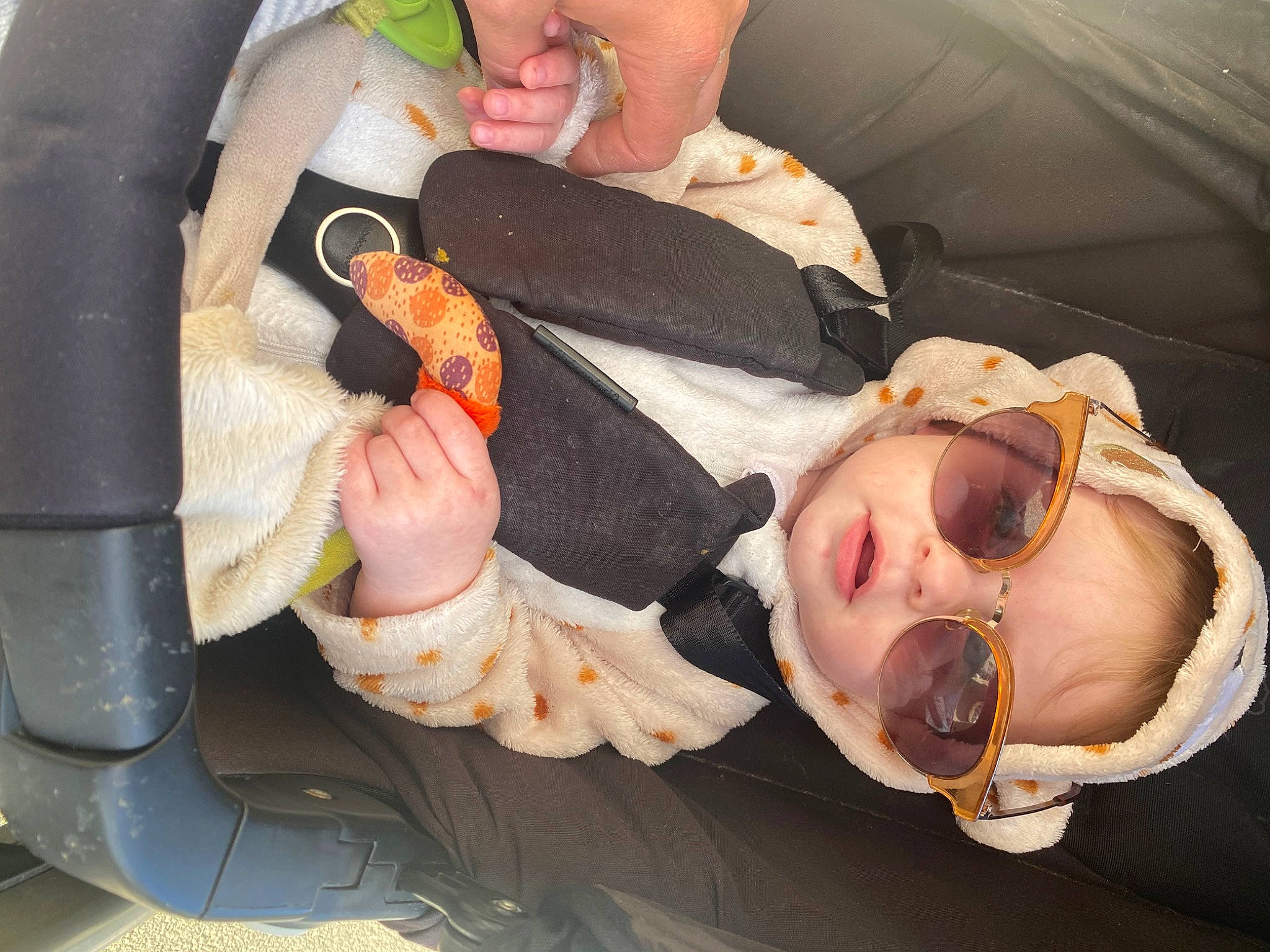 Chelsea participe au concours pour gagner de l'argent avec cette photo : audio_equipment, baby, baby_products, baby_toddler_clothing, car_seat, child, comfort, comfort_food, eyelash, eyewear, finger, fur, mouth, nail, orange, person, sunglasses, thumb, tie, toddler