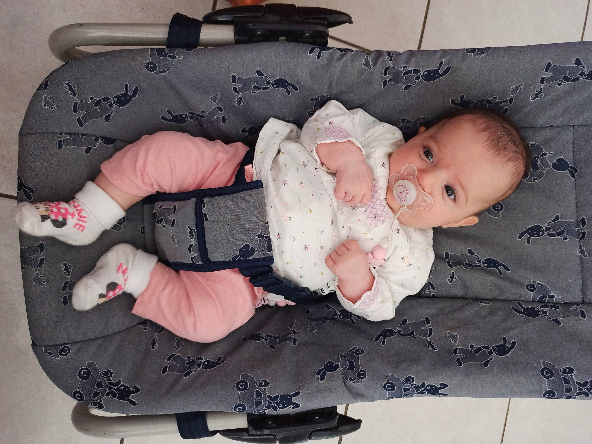 Amélie participe au concours pour gagner de l'argent avec cette photo : baby, baby_products, baby_toddler_clothing, cheek, child, comfort, fashion_accessory, pattern, person, personal_protective_equipment, pink, room, sitting, sleeve, toddler, white