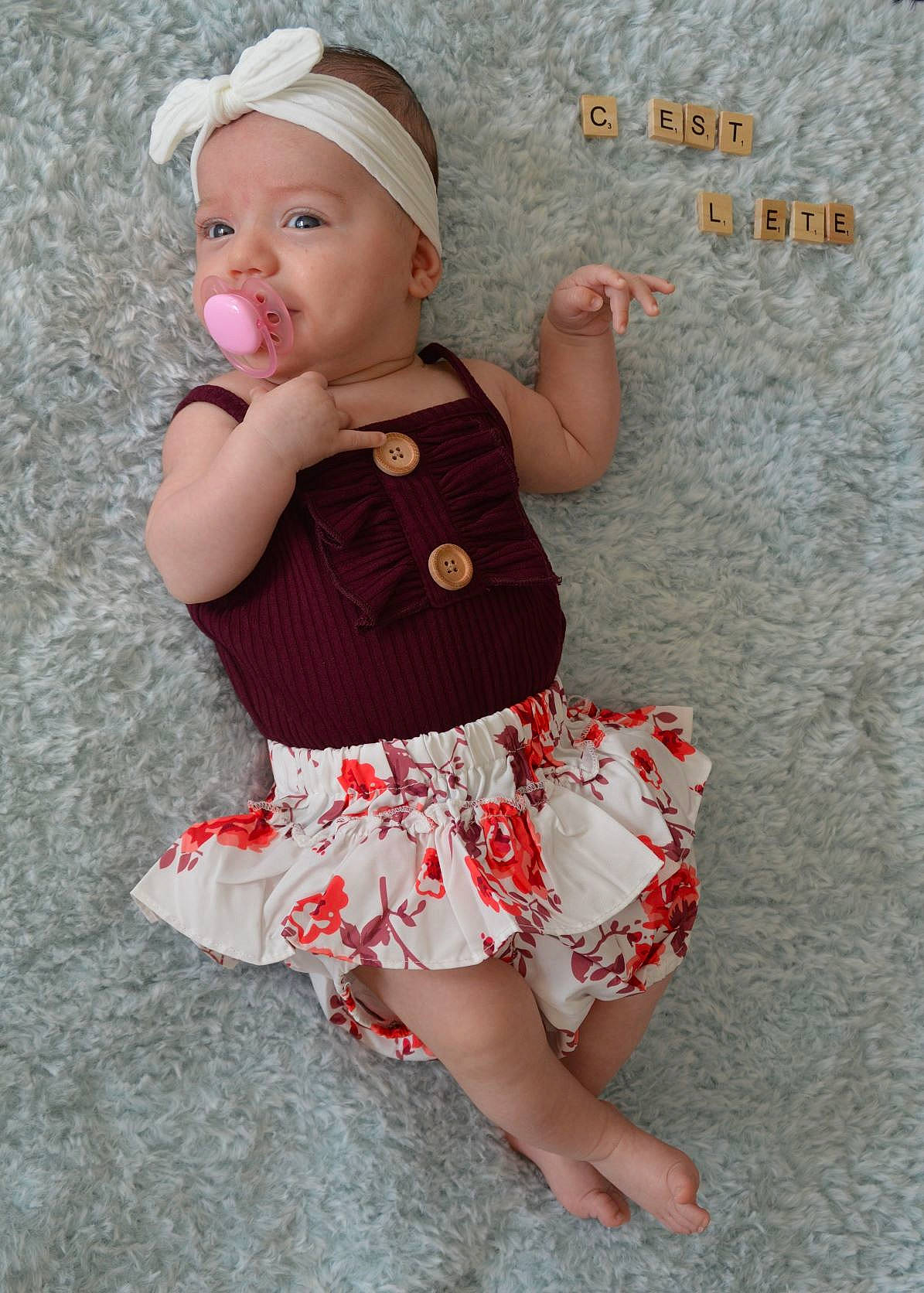 Amélie participe au concours pour gagner de l'argent avec cette photo : abdomen, baby, baby_toddler_clothing, child, day_dress, face, facial_expression, finger, happy, headwear, human_body, human_leg, pattern, person, pink, skin, sleeve, t_shirt, thigh, toddler