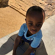 Zaamir Boyd joined the competition — help win amazing prizes! child, boy, outdoor, sidewalk, stone_wall, shadow, blue_shirt, colorful_shoes, sunlight, crouching, concrete, expression, casual_clothing, daylight, young, person, skin, hair, pose, background