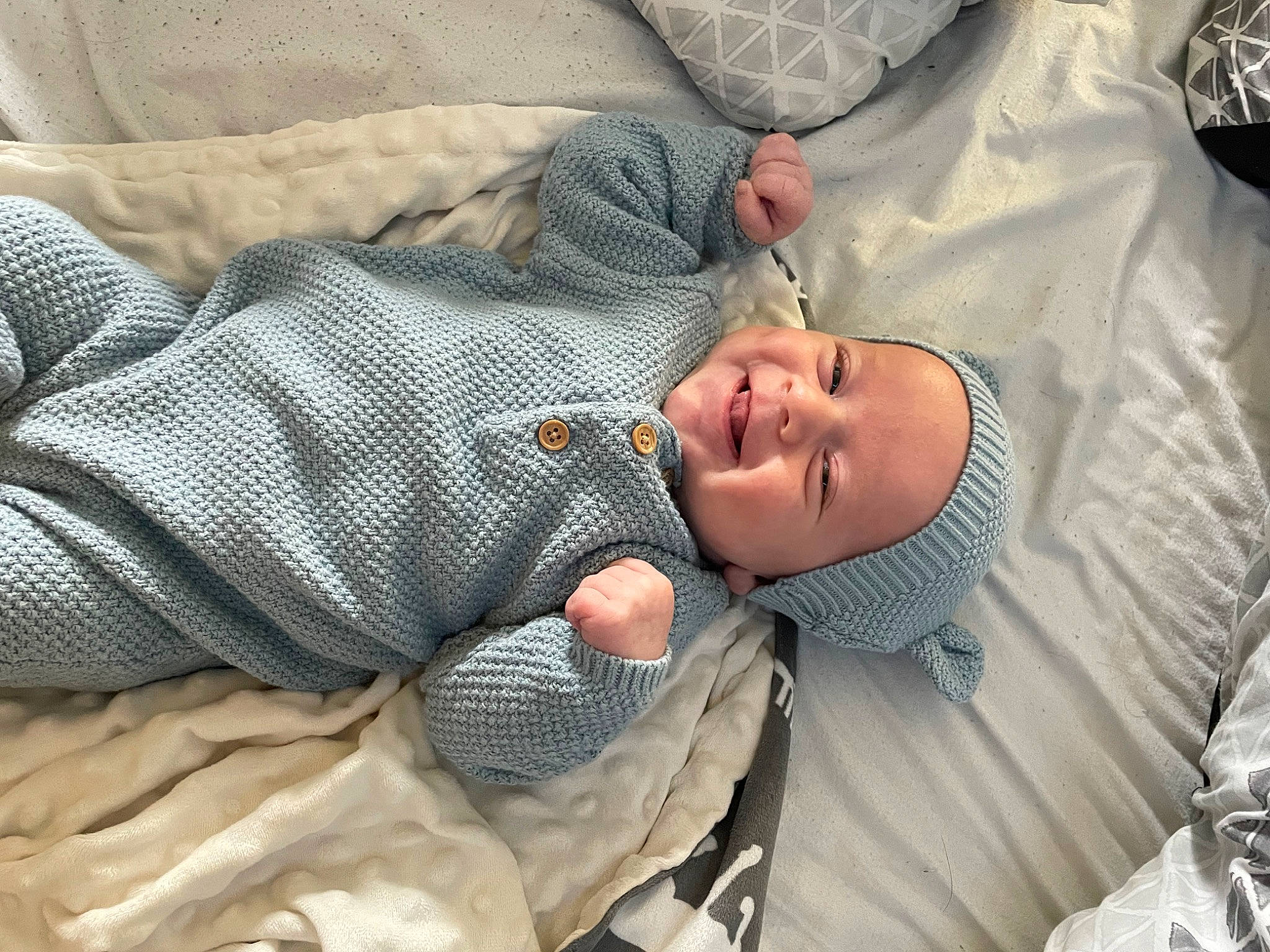 Kane is registered to the contest to win money with this photo: baby, baby_products, baby_toddler_clothing, child, comfort, elbow, finger, grass, hat, headwear, joy, linens, nap, pattern, person, sleep, sleeve, smile, t_shirt, toddler