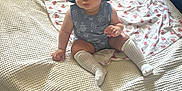 Yamanie is registered to the contest to win money with this photo: baby, bed, blanket, blue_outfit, carpet, child, cute, decor, floor, furniture, hat, home, indoor, person, portrait, pout, sitting, textile, white_socks, young_child
