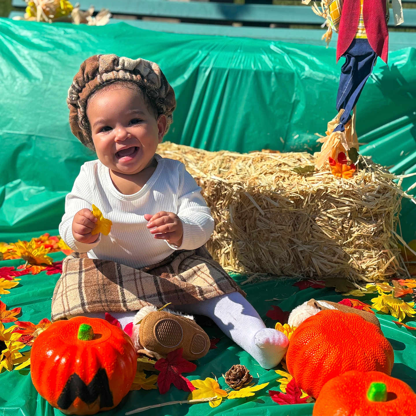 Yamanie joined the competition — help win amazing prizes! autumn, child, costume, decoration, fall, festive, happy, hay_bale, headwear, leaves, outdoor, plaid_skirt, playful, pumpkin, seasonal, sitting, smiling, sunflower, toddler, toy