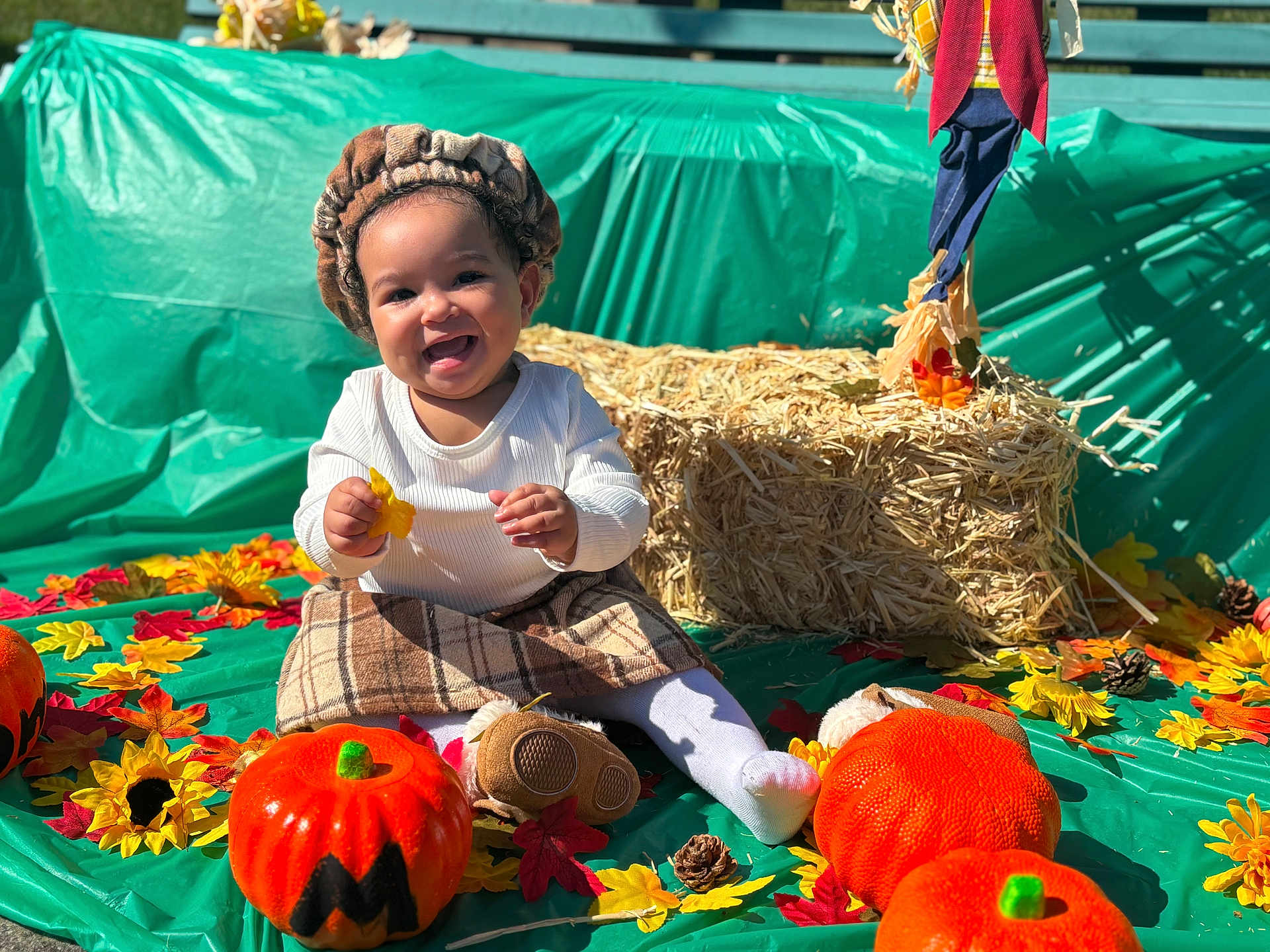Yamanie joined the competition — help win amazing prizes! autumn, child, costume, decoration, fall, festive, happy, hay_bale, headwear, leaves, outdoor, plaid_skirt, playful, pumpkin, seasonal, sitting, smiling, sunflower, toddler, toy