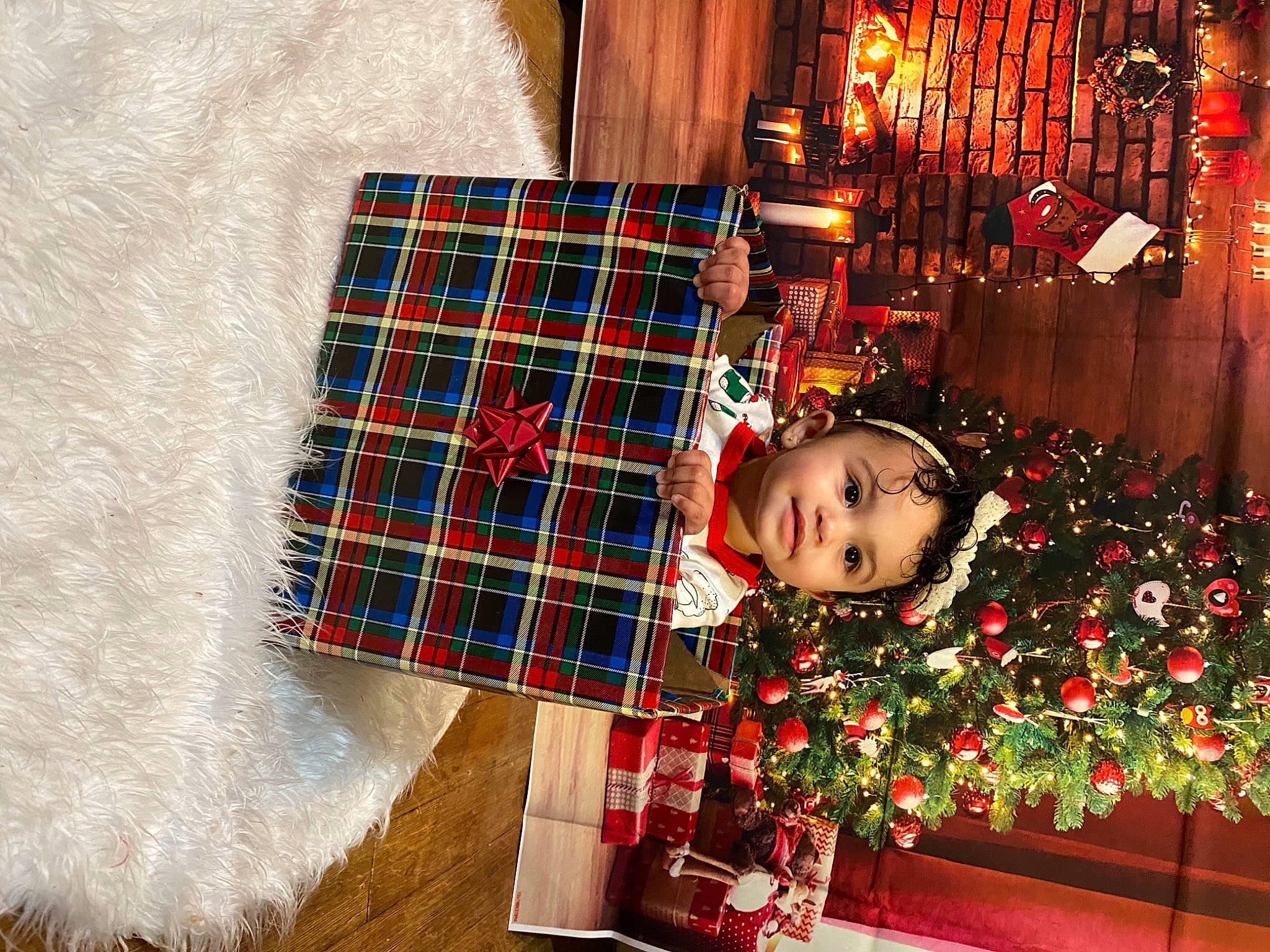 Zaniyah is registered to the contest to win money with this photo: christmas, christmas_decoration, christmas_ornament, christmas_tree, event, flooring, happy, holiday, holiday_ornament, ornament, pattern, person, plaid, rectangle, red, sleeve, tartan, textile, toddler, white