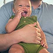 Makenai is registered to the contest to win money with this photo: baby, child, smile, happy, green_outfit, adult_hand, holding, portrait, close_up, indoor, person, skin, face, arm, casual_clothing, cute, infant, human, expression, joyful