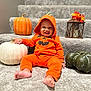 Makenai joined the competition — help win amazing prizes! baby, carpet, child, costume, cute, decoration, face, festive, foot, halloween, happy, hood, indoors, lantern, orange_hoodie, playful, pumpkin, sitting, smile, stairs