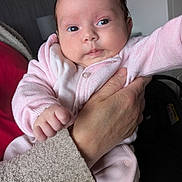 Timisha is registered to the contest to win money with this photo: baby, infant, child, hand, pink_clothing, person, portrait, indoor, soft_light, cute, newborn, holding, sleeve, face, skin, fingertips, warm, cozy, human, expression