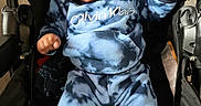 Armoni is registered to the contest to win money with this photo: baby, blue_clothing, calvin_klein, casual, child, cute, determined, expression, face, fist, footwear, indoor, infant, person, portrait, shoe, sitting, stroller, tie_dye, white_shoe