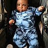 baby, blue_clothing, calvin_klein, casual, child, cute, determined, expression, face, fist, footwear, indoor, infant, person, portrait, shoe, sitting, stroller, tie_dye, white_shoe