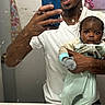Armoni is registered to the contest to win money with this photo: art, baby, bathroom, clothing, facial_hair, hand, holding, indoor, man, mirror, painting, pajamas, phone, portrait, reflection, selfie, serious, sink, smile, soap_dispenser