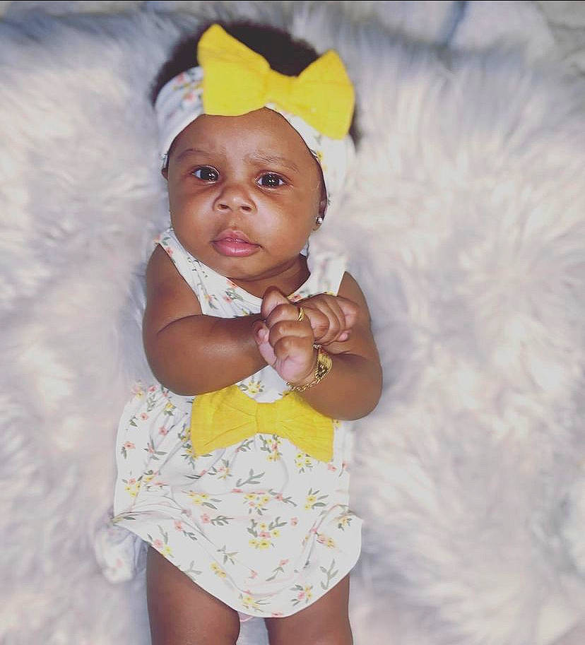 Kaliah is registered to the contest to win money with this photo: arm, baby, baby_toddler_clothing, cap, child, dress, eye, face, finger, fun, gesture, happy, head, headwear, iris, nose, person, pink, skin, sleeve