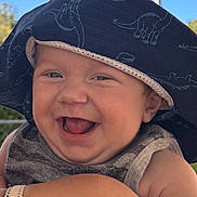 Liam joined the competition — help win amazing prizes! baby, child, dinosaur_hat, hat, smile, laughing, happy, outdoor, sky, clouds, person, infant, cute, portrait, sunlight, arm, shoulder, clothing, closeup, skin