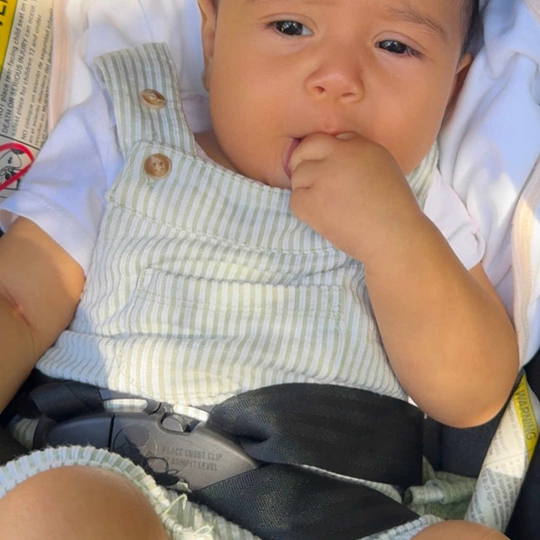 Nelfil joined the competition — help win amazing prizes! baby, infant, child, car_seat, harness, sitting, portrait, face, eyes, hand, fist, chewing, curious, calm, striped_outfit, clothing, indoor, vehicle, photography, safe