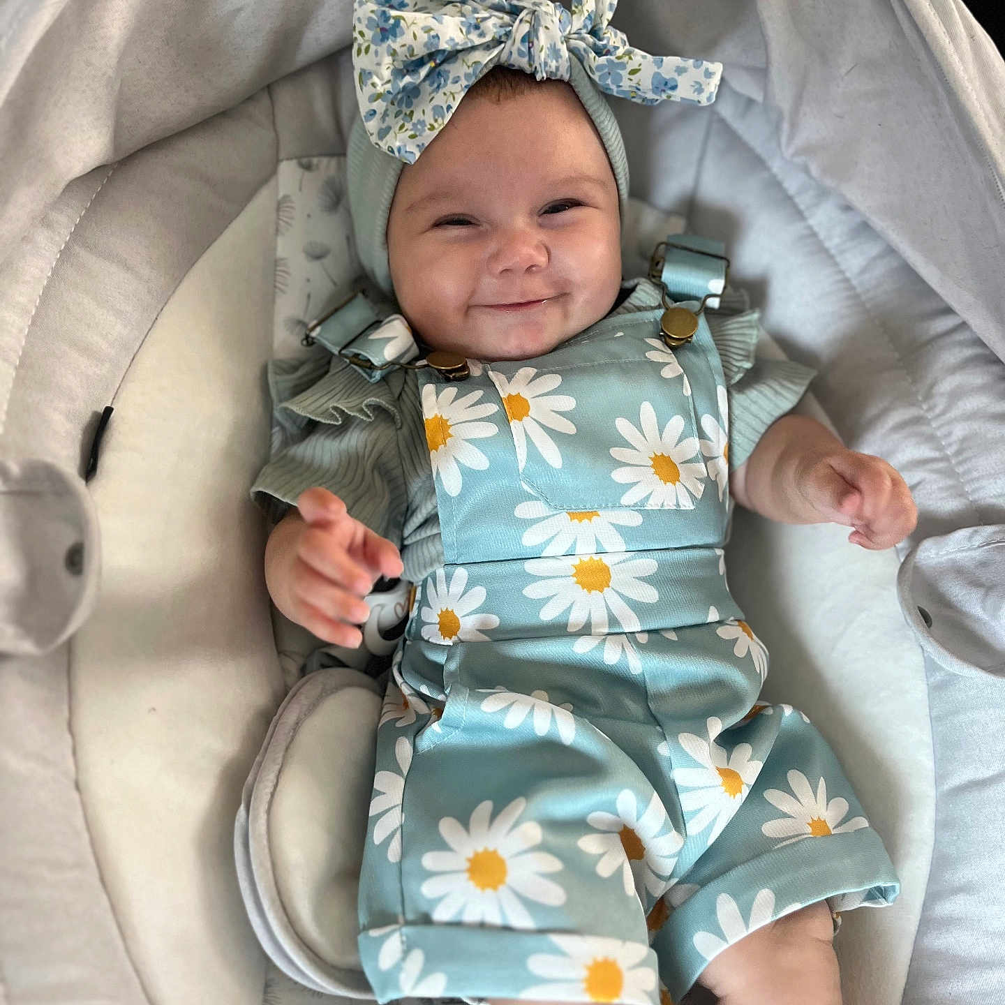 Zeïly a rejoint le concours — aidez-le/la à gagner de superbes lots ! baby, babywear, blue_outfit, bow, child, clothing, comfortable, cushion, cute, daisies, flower_pattern, happy, headband, indoors, infant, person, portrait, seat, skin, smile