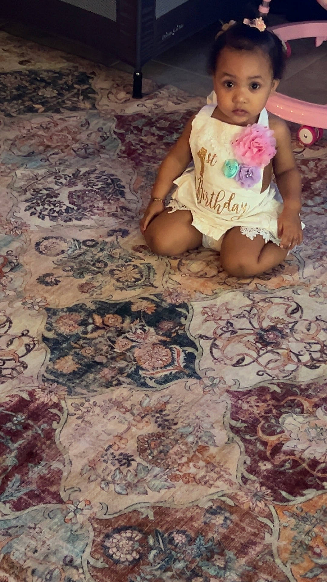 Jazelle is registered to the contest to win money with this photo: birthday, bracelet, carpet, celebration, child, curious, cute, decor, dress, floor, flower, home, indoor, infant, kneeling, pattern, person, portrait, toddler, toy